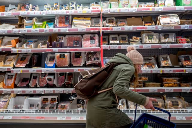 A customer shops for meat at a Sainsbury’s supermarket.