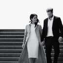 A black and white image of Meghan Markle and Prince Harry walking down a flight of stairs together, hand in hand and smiling (Credit: Netflix) 
