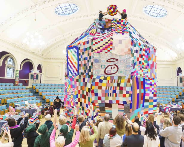 People watch as workers place a giant bobble on top of a 23 foot high bobble hat in celebration of the 20th anniversary of the innocent Big Knit in partnership with Age UK (photo: Dominic Lipinski/PA Wire)