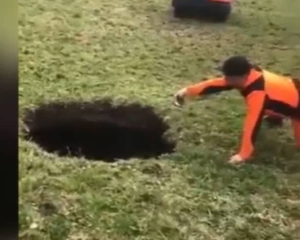 Hiker points to a giant sinkhole estimated to be around 20m deep