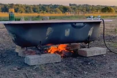 Robyn's outdoor bathtub heated by open flame.
