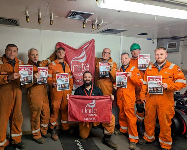 Offshore workers at Ninian Central platform with posters backing Unite the Union's No Ban Without a Plan campaign.