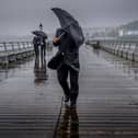 People battle against the wind and rain.