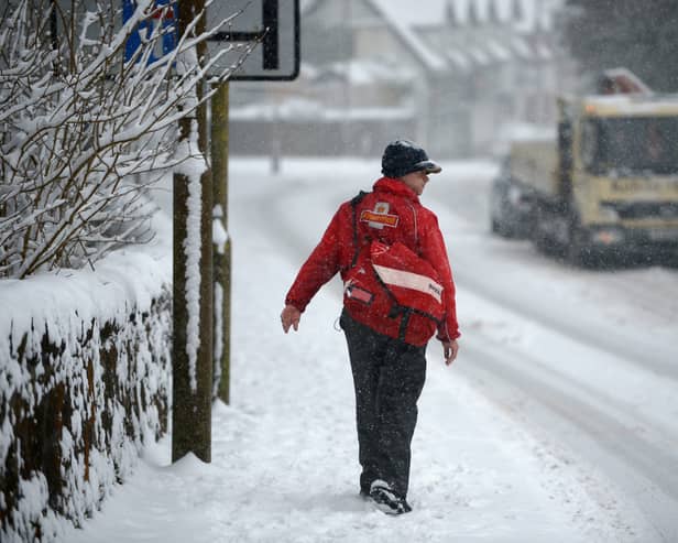 A postman makes his way through the snow.