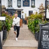 Former England rugby international Danny Care kicking a ball "into space" from outside the Greene King sport pub The Barmy Arms in Twickenham
