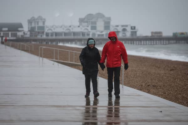 A couple walk in heavy rain on the South Parade Pier, in Portsmouth.