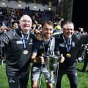 Brad Spencer with the Scottish Championship trophy alongside Falkirk management team John McGlynn and Paul Smith