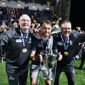 Brad Spencer with the Scottish Championship trophy alongside Falkirk management team John McGlynn and Paul Smith