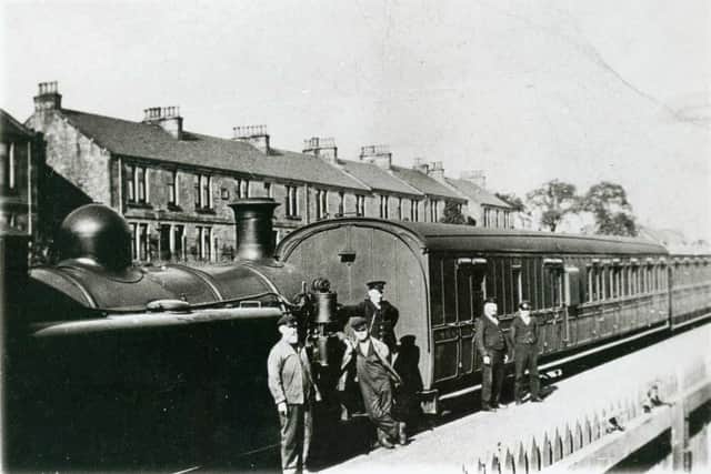 Train and crew at Bonnybridge Railway station. View of station with train at platform with tank engine and carriages.  The crew are by the engine - the driver (Peter Leith) and fireman in light coloured uniform, the guard in dark.  There are also two porters.  There is a tenement in the background.

* COPYRIGHT FALKIRK ARCHIVES. PERMISSION MUST BE SOUGHT BEFORE USE *