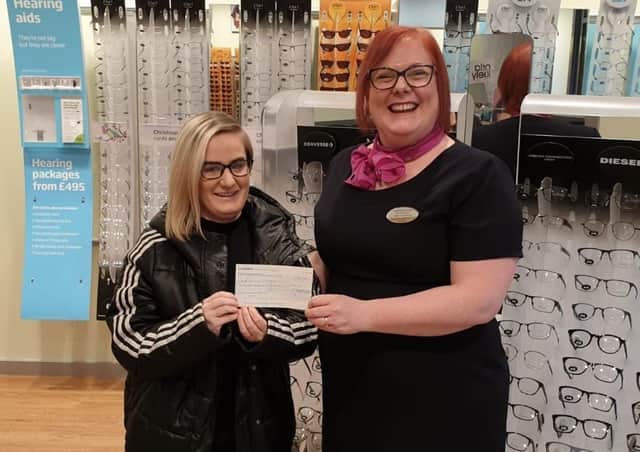 Customer Nicole Cook, left, receives her prize from store manager Laura Owens.