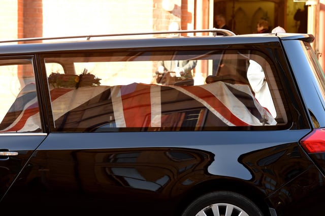 The hearse arrives at St Robert's Church with John's coffin decked with the Union Jack flag, his cap and his medals
