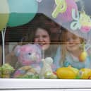 Childminder Yvonne Nicoll with cousins Olivia Anderson (10) and Jessica Hamilton (4) who have a parent working with the NHS, with a bear in the window in Bonnybridge.