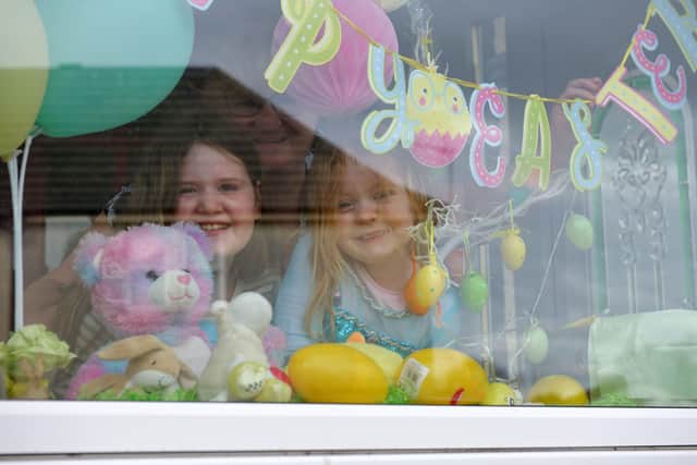 Childminder Yvonne Nicoll with cousins Olivia Anderson (10) and Jessica Hamilton (4) who have a parent working with the NHS, with a bear in the window in Bonnybridge.
