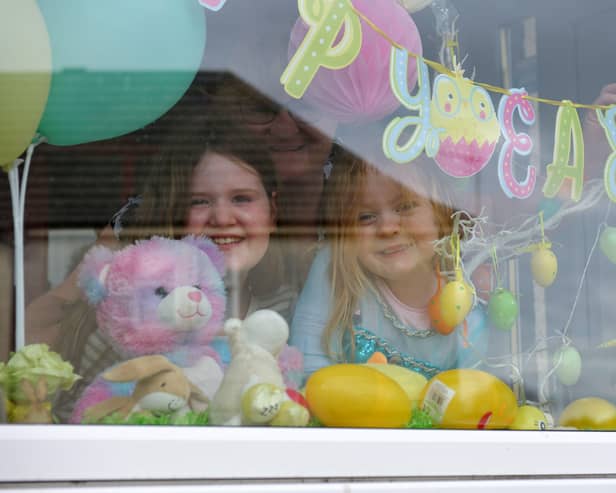 Childminder Yvonne Nicoll with cousins Olivia Anderson (10) and Jessica Hamilton (4) who have a parent working with the NHS, with a bear in the window in Bonnybridge.