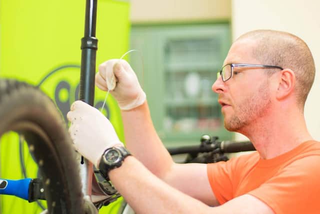 Forth Environment Link Active Travel Coordinator Ray Burr servicing a bike in the Falkirk Active Travel Hub.