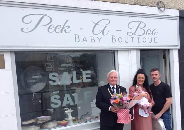 Provost William Buchanan officially opened Peek-A-Boo Baby Boutique.  He is pictured with owners Conny Bannan and Michael Wallace with daughter Perrie.