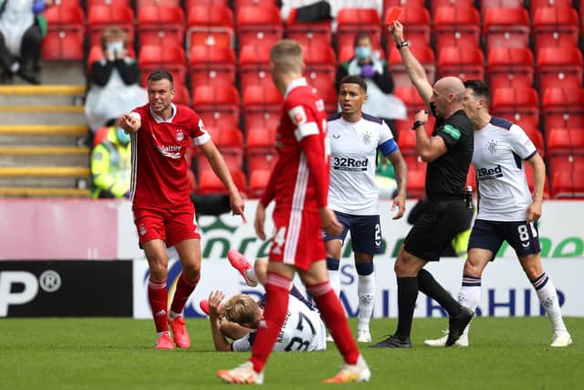 ABERDEEN, SCOTLAND - AUGUST 01: Andrew Considine of Aberdeen is shown a red card by referee Bobby Madden after fouling Scott Arfield of Rangers FC who goes down to the floor during the Ladbrokes Premiership match between Aberdeen and Rangers at Pittodrie Stadium on August 01, 2020 in Aberdeen, Scotland. Football Stadiums around Europe remain empty due to the Coronavirus Pandemic as Government social distancing laws prohibit fans inside venues resulting in all fixtures being played behind closed doors. (Photo by Andrew Milligan/Pool via Getty Images)