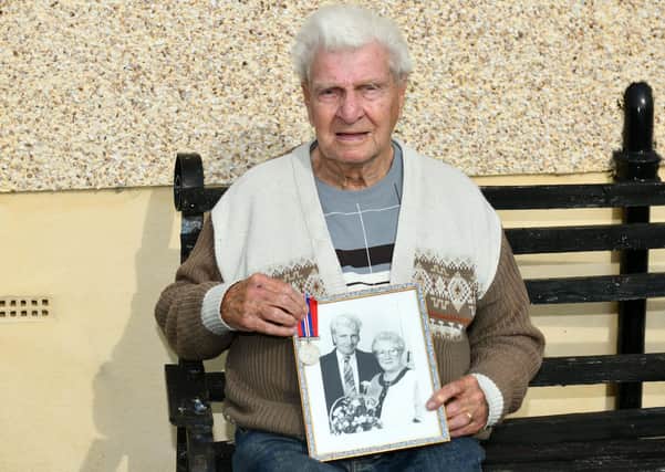 Alex McIntosh (98) with a photograph of him and his late wife Agnes. Pic: Michale Gillen.