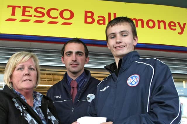 FRIENDS CHEQUE. Gareth Fall (right) from Ballymoney United FC Youth Academy, pictured on Thursday presenting a donation to Diana Hendrie, who was accepting it on behalf of  Friends of the Brook, Coleraine. The money is part proceeds raised by the Club through bag packing at Tesco. And looking on is Kyle Moore, Hardlines Line Manager at Tesco.BM40-014SC.
