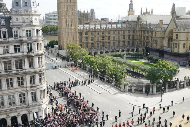 The State Gun Carriage carries the coffin of Queen Elizabeth II, draped in the Royal Standard with the Imperial State Crown and the Sovereign's orb and sceptre, in the Ceremonial Procession following her State Funeral at Westminster Abbey, London. Picture date: Monday September 19, 2022.