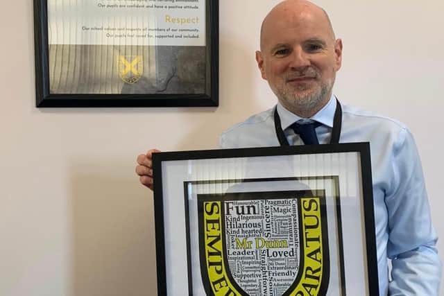 Paul Dunn displays one of the leaving gifts he received from pupils as he announced his departure from Grangemouth High School after eight years in charge