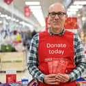 A Tesco volunteer holding a shopping list guide for donations at the launch of the Tesco Food Collection