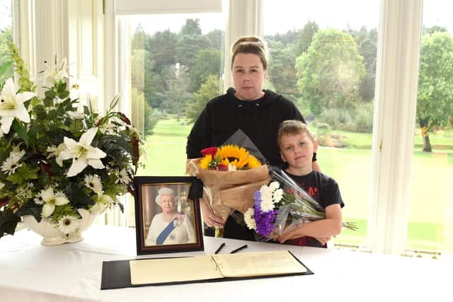 Catherine Milne, 36, and Aidan Muir, seven, who brought flowers in memory of HM The Queen