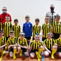 Carronshore Primary School with new football strips thanks to parent Nathaniel Hutton, Director of SMN Engineering, back right. The team with their coach and janitor Mr Aitchison. Pic: Michael Gillen