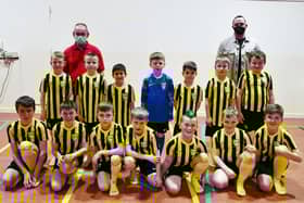 Carronshore Primary School with new football strips thanks to parent Nathaniel Hutton, Director of SMN Engineering, back right. The team with their coach and janitor Mr Aitchison. Pic: Michael Gillen