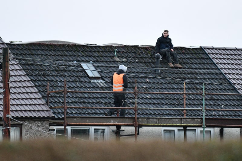 Workmen inspecting a house roof in Falkirk.