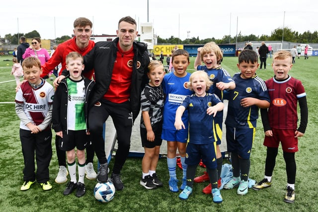 Warriors duo Ross Taylor and Adam Brown poses for a picture with some of the youngsters who attended the community day