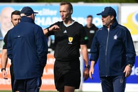 John McGlynn and assistant Paul Smith discusses penalty award with referee Steven Kirkland post match