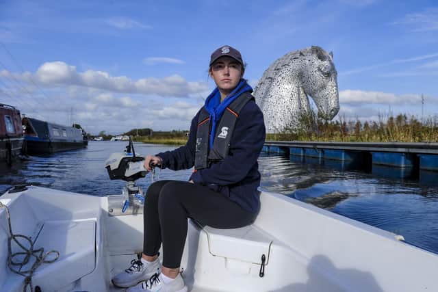 Scottish Canals activities assistant Rebecca Brown at the helm of one of its electric boats on the Forth & Clyde Canal at the Kelpies. Pic: Lisa Ferguson