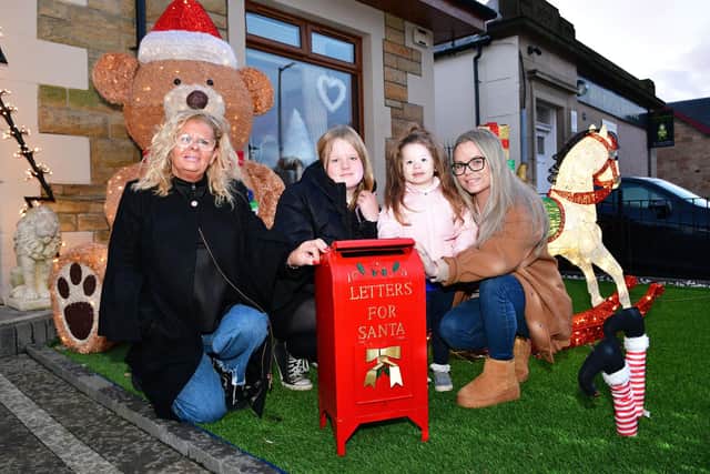 Senga Morris, Freya Ritchie , 11, Jorja Ritchie, 3, and Nicole Ritchie have been passing on children's Christmas letters to Santa with their special post box in their Wallace Street Winter Wonderland 
(Picture: Michael Gillen, National World)