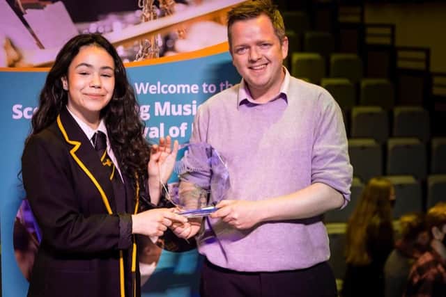 Jasmin Milne receives her winners trophy from instrumental instructor Jonny Graham