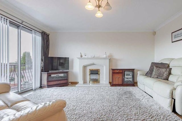 The stunning lounge boasts an impressive fire feature, while also opening up to a balcony to enjoy the views.