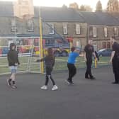 Firefighters enjoy some fun with youngsters on the basketball court at a Twilight Sports session