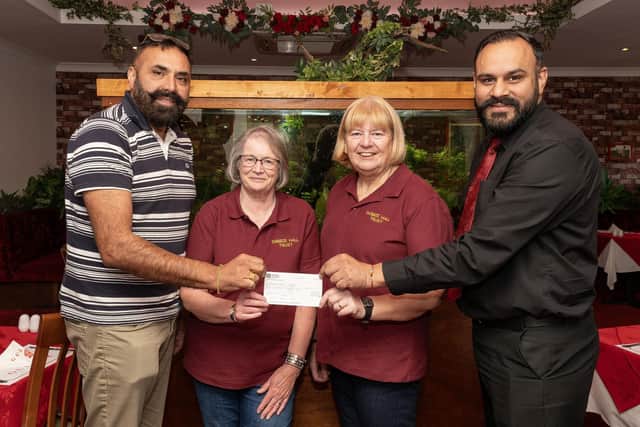 Owners of Gulnar Tandoori, Boota Singh and Navjot Gosal hand over a cheque for £400 to Barbara Anderson and Lesley Guthrie from the Dobbie Hall Trust. (Pic: Michael Gillen)