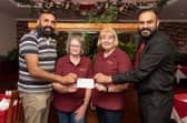 Owners of Gulnar Tandoori, Boota Singh and Navjot Gosal hand over a cheque for £400 to Barbara Anderson and Lesley Guthrie from the Dobbie Hall Trust.  (Pic: Michael Gillen)