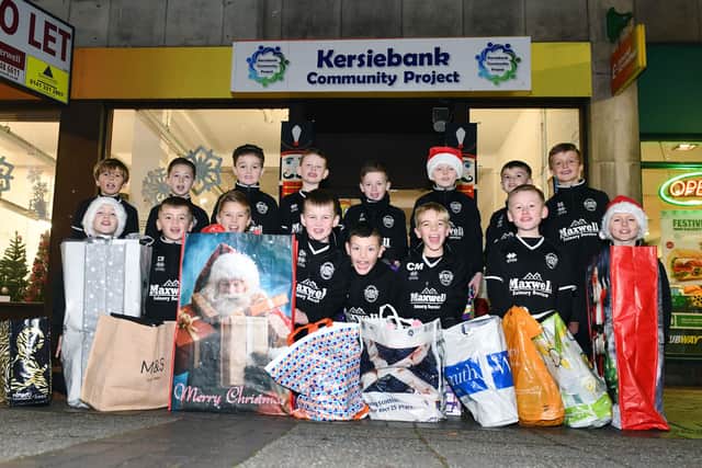 Gairdoch United 2013's hand over toys and gifts that they bought after fundraising to Kersiebank Community Project.