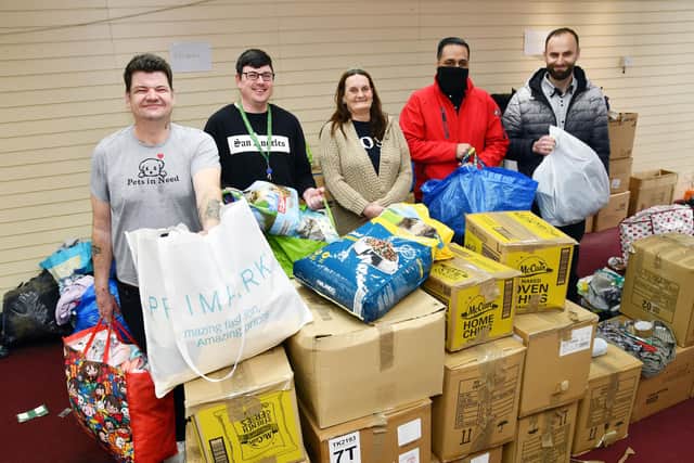 Pets in Need volunteers sort through the massive amount of donations they have received in the last few days for the people of Ukraine