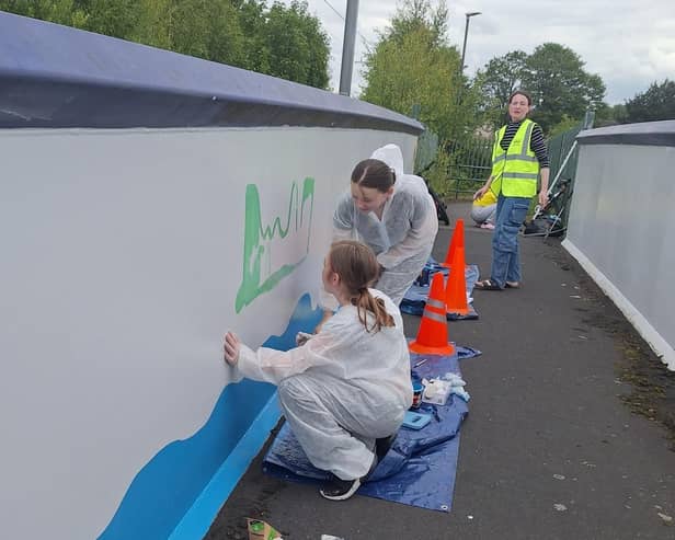 Youngsters at work on the mural on the footbridge in Camelon. Pic: Contributed
