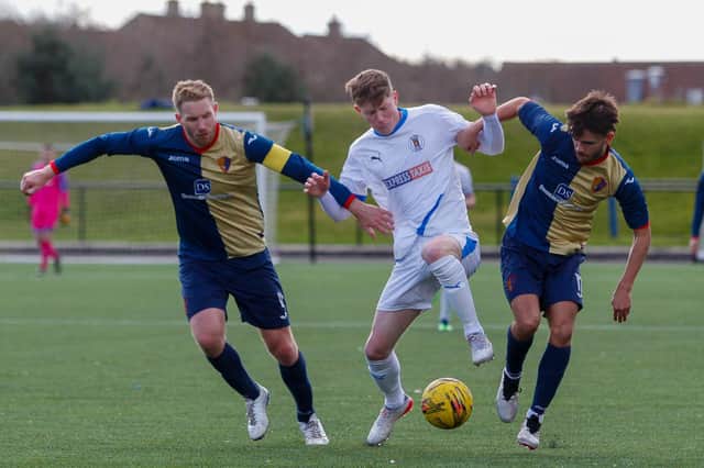 Kyle Wilson looks to hold onto the ball with two EK players in close attention (Pictures: Scott Louden)