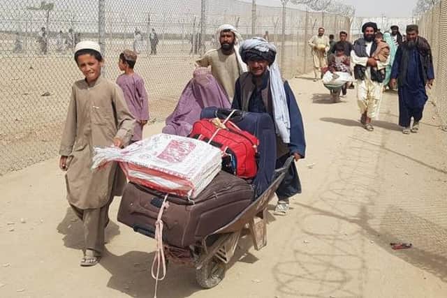 Afghans pictured fleeing their country, at Kabul Airport, after the Taliban took back control of the country. Photo: Getty Images.