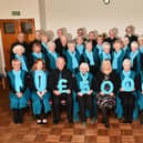 Strathcarron Singers present to hospice CEO Mags McCarthy, centre. Pic: Michael Gillen