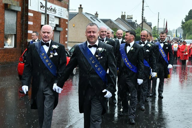 Braving the elements, the Free Colliers march through the streets of several Braes villages.