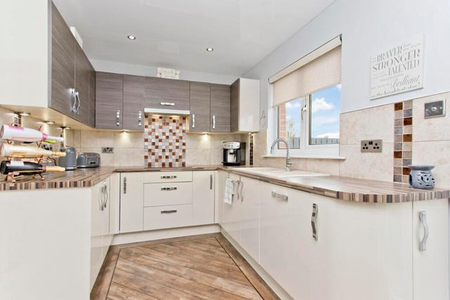 The kitchen boasts a fantastic range of base and wall units, luxury floor tiling with border, design-led tap, ceramic hob, and integrated dishwasher.