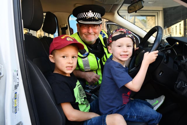 Siting inside this British Transport Police car are Callan Farquhar , seven, and Aidan Farquhar five, with Inspector Chris Jamieson