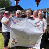 Members of the Somerville family celebrating the Jubilee Tea Party with Coronation tablecloth embroidered by their motherand grandmother for the Queen’s Coronation in 1953.