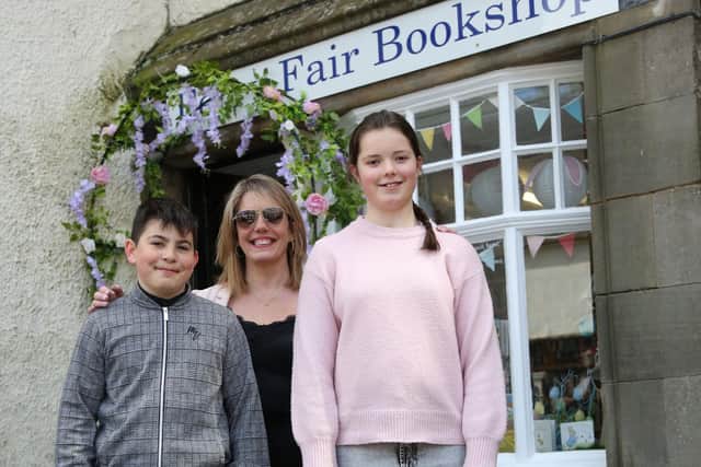 (L to R) Herald Charlie Doga, Ferry Fair Chairperson Tracy Guyan and Queen Grace Higgins. Outside the refurbished Ferry Fair bookshop.